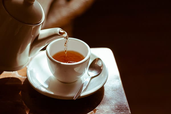 Tee wird in eine Tasse gegossen